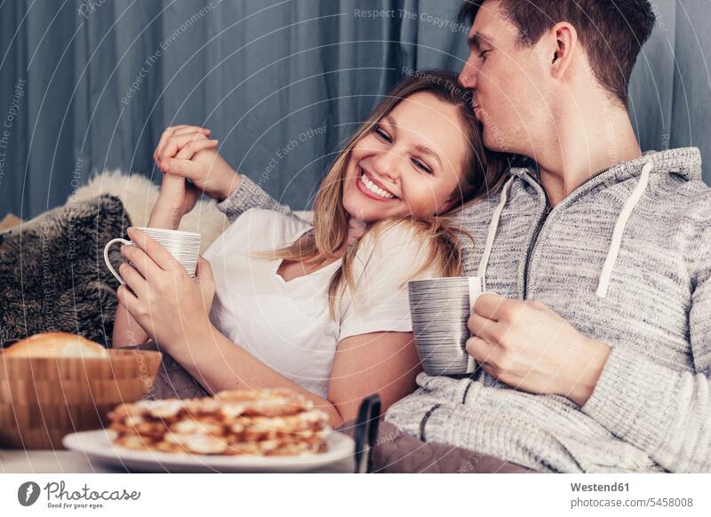 Affectionate young couple having breakfast in bed beds twosomes partnership couples Breakfast relaxed relaxation people persons human being humans human beings