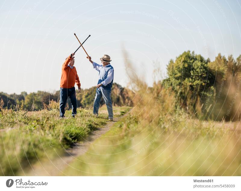 Two old friends fencing in the fields with their walking sticks Field Fields farmland rival rivals fighting fence Hiking Sticks Walking Cane playing Best Friend