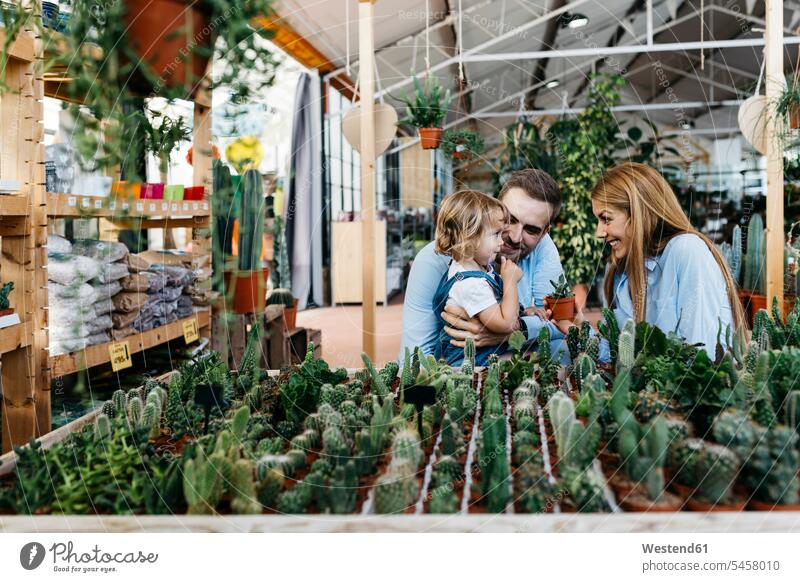 Mother, father and daughter in the cactus area inside a garden center human human being human beings humans person persons client clientele clients customers