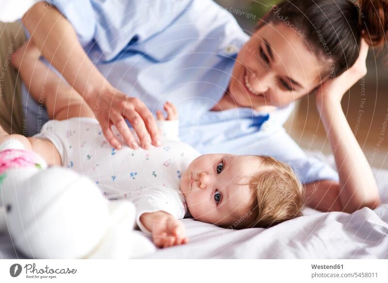 Happy mother and baby relaxing in bed at home mommy mothers ma mummy mama infants nurselings babies relaxed relaxation happiness happy beds parents family