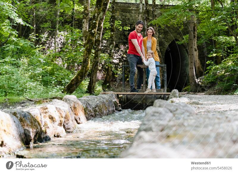 Parents with daughter looking at dam while standing in forest color image colour image Germany leisure activity leisure activities free time leisure time