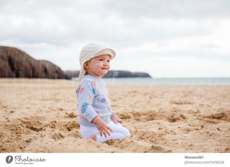 Spain, Lanzarote, content baby girl crouching on the beach beaches infants nurselings babies pleased perching Perched baby girls female people persons