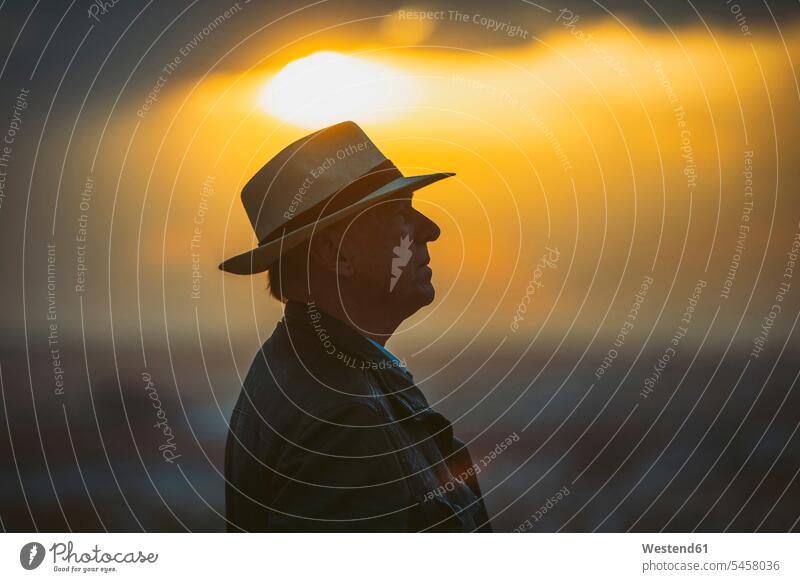 Senior man wearing hat against sky during sunset color image colour image outdoors location shots outdoor shot outdoor shots sunsets sundown atmosphere Idyllic
