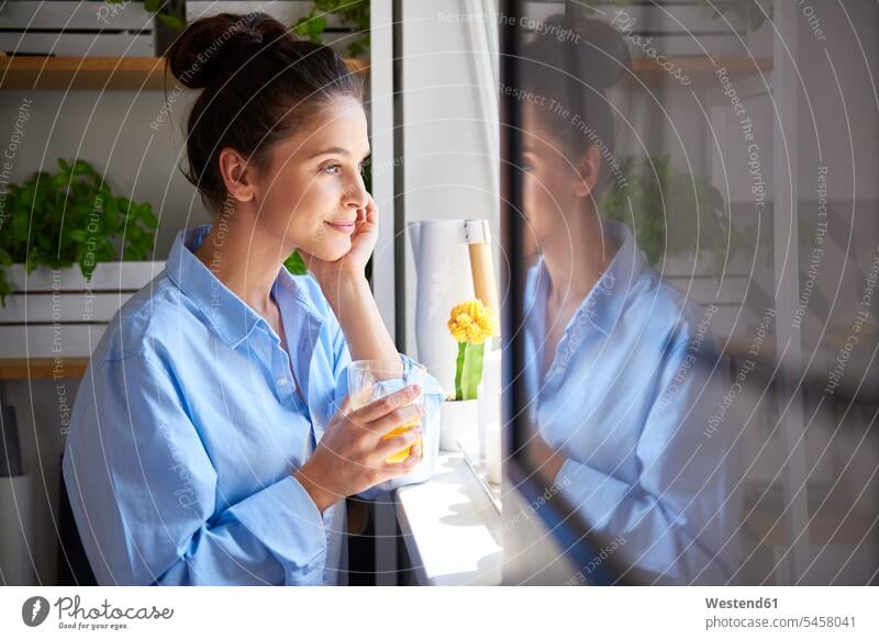 Young woman drinking orange juice in her kitchen caucasian caucasian ethnicity caucasian appearance european copy space Glass Drinking Glasses holding