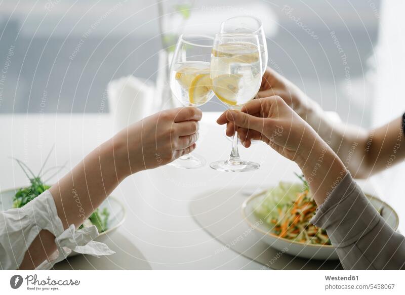 Close-up of three women toasting glasses of water in a restaurant female friends dish dishes togetherness healthy eating nutrition community Companionship