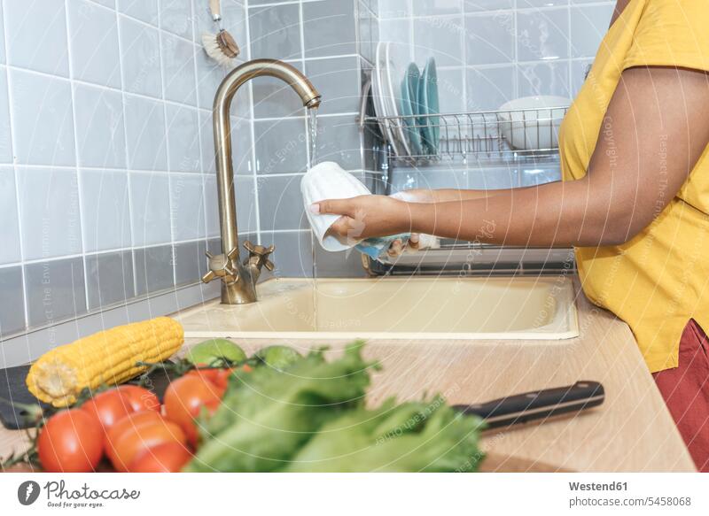 Close-up of woman washing a cup in kitchen human human being human beings humans person persons African black black ethnicity coloured 1 one person only