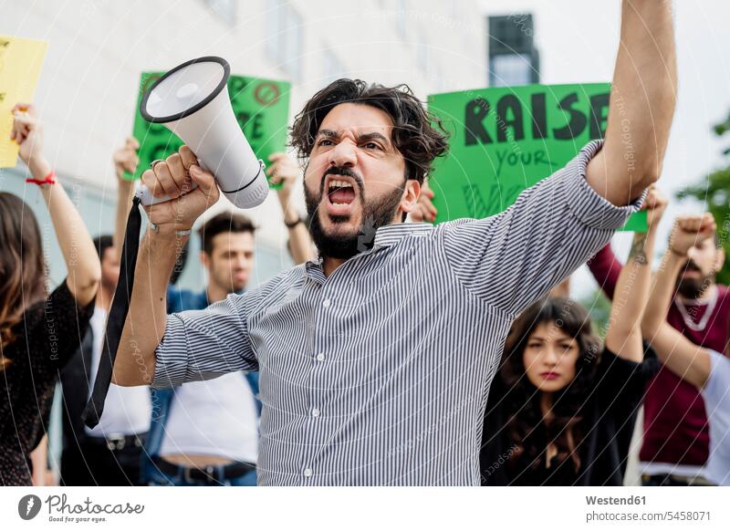 Man holding megaphone screaming with protestors on street color image colour image casual clothing casual wear leisure wear casual clothes Casual Attire