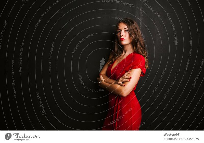 Portrait of young woman wearing red dress dresses stand Lifestyle Attractiveness beautiful good-looking Handsome pretty portraits Eye Contact