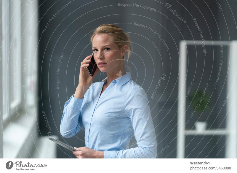 Young businesswoman talking on cell phone in office business life business world business person businesspeople business woman business women businesswomen