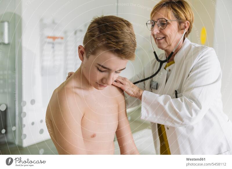 Doctor examining teenage boy with a stethoscope health healthcare Healthcare And Medicines medical medicine disease diseases ill illnesses sick Sickness