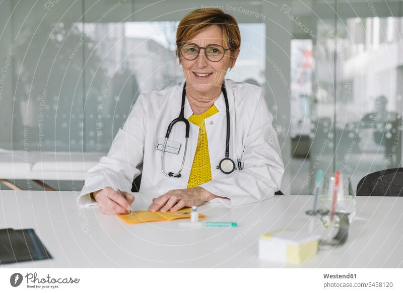 Portrait of smiling doctor filling out immunization card human human being human beings humans person persons caucasian appearance caucasian ethnicity european