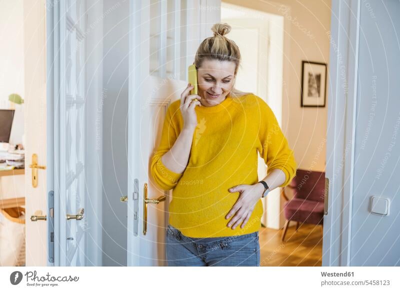 Pregnant woman at home talking on the phone jumper sweater Sweaters telecommunication phones telephone telephones cell phone cell phones Cellphone mobile