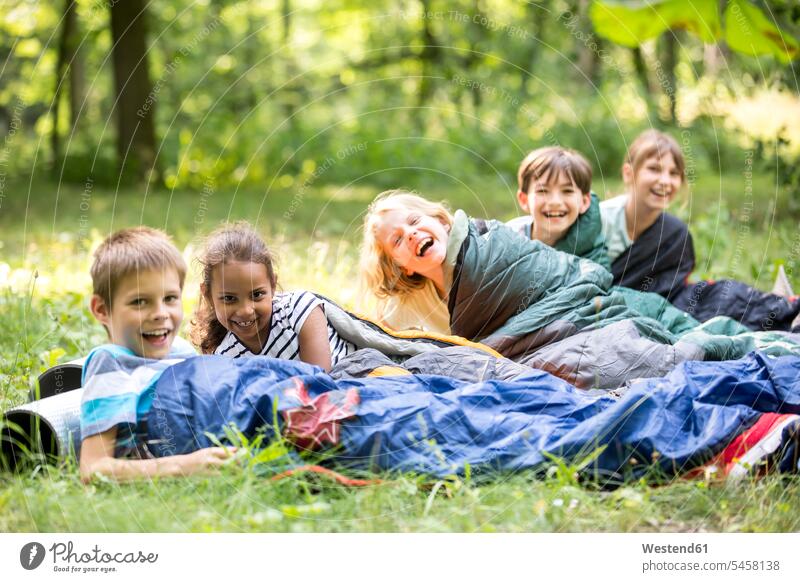 School children camping in forest, lying in sleeping bags learn delight enjoyment Pleasant pleasure colour colours laying down lie lying down explore exploring