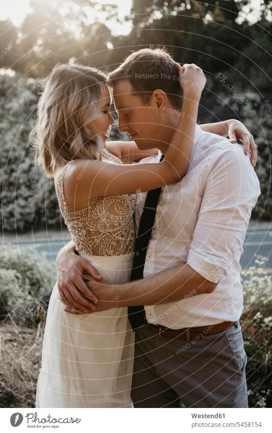 Affectionate bride and groom hugging outdoors Celebration Event Celebrations Ceremonies Ceremony Festivities Festivity getting married Marriage marrying brides