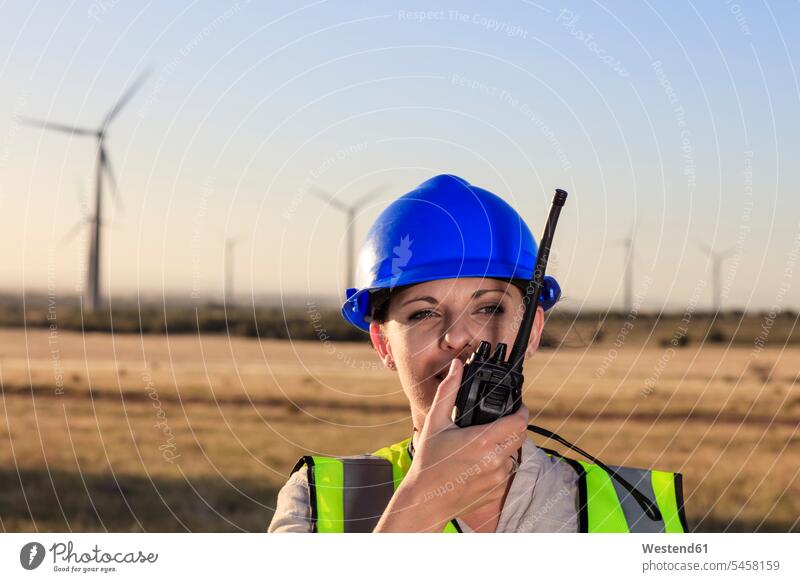 Female technician using walkie-talkie on a wind farm female technician female technicians walkie talkie walkie-talkies walkie talkies two-way radios wind park