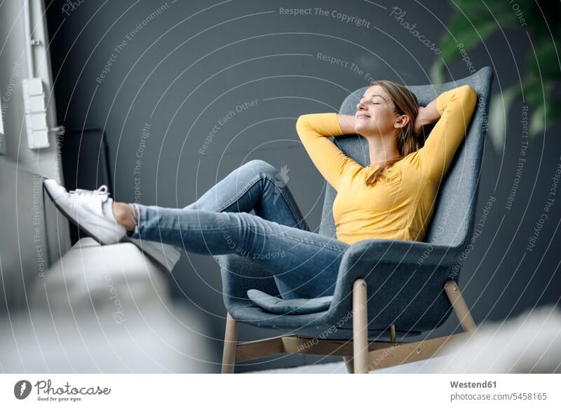 Smiling young woman relaxing in armchair human human being human beings humans person persons caucasian appearance caucasian ethnicity european 1
