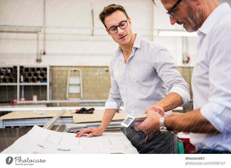 Two businessmen in factory discussing component and plan components part parts Businessman Business man Businessmen Business men discussion factories plans