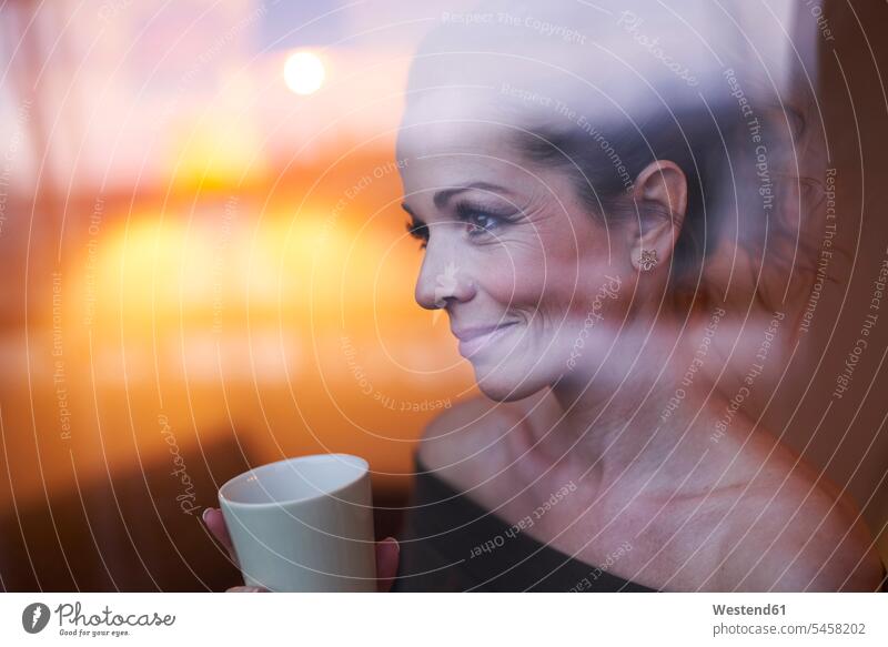 Portrait of brunette woman with cup behind windowpane looking away windows panes window glass window glasses Window Pane windowpanes smile drink in the evening