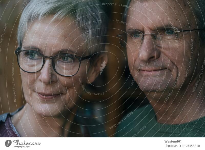 Confident senior couple looking out of window windows elder couples senior couples view seeing viewing twosomes partnership confidence confident adult couple