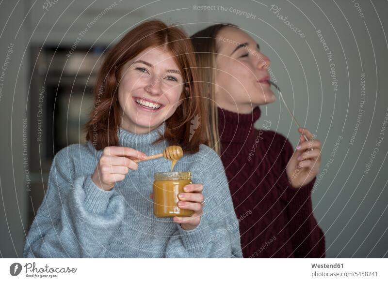 Two best friends tasting honey in the kitchen Honey domestic kitchen kitchens female friends taste Food foods food and drink Nutrition Alimentation