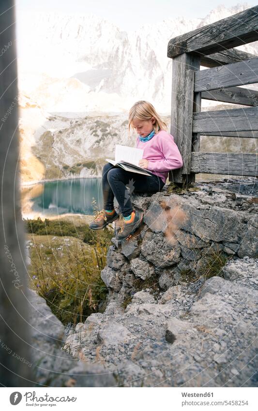 Austria, Tyrol, girl reading book in mountainscape females girls books mountainscapes mountain scenery Mountainous Region landscape landscapes terrain child