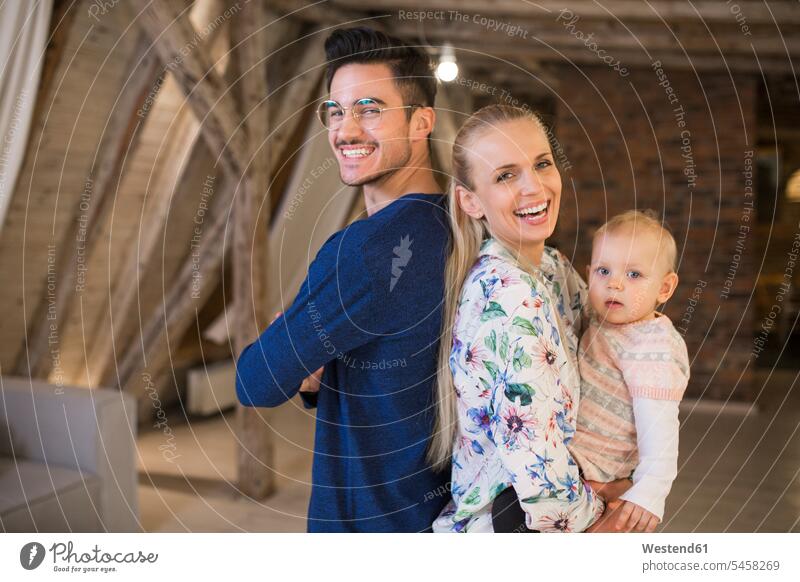 Portrait of happy young parents with their baby girl at home infants nurselings babies family families portrait portraits happiness people persons human being