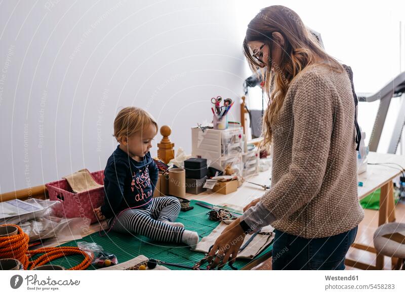 Mother with little daughter at home working with fashion accessories At Work daughters mother mommy mothers ma mummy mama accessory fashionable child children