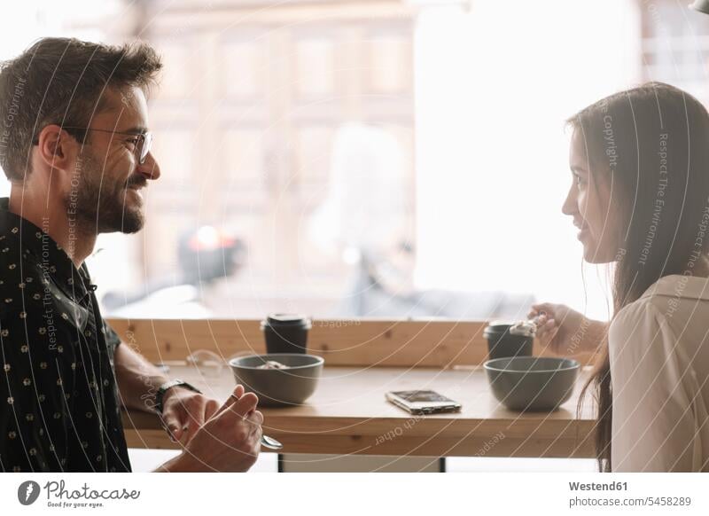 Young couple having breakfast in a cafe windows telecommunication phones telephone telephones cell phone cell phones Cellphone mobile mobile phones mobiles