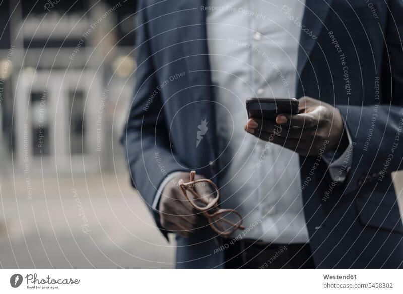 Crop view of businessman holding glasses and smartphone business life business world business person businesspeople Business man Business men Businessmen