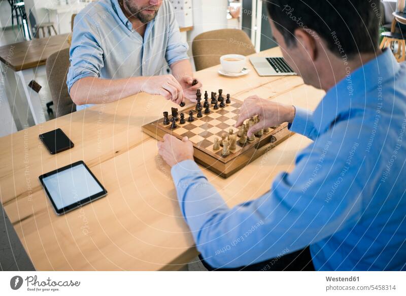 Two men playing chess man males board game board-games boardgame board games parlor game parlour games parlor games Adults grown-ups grownups adult people