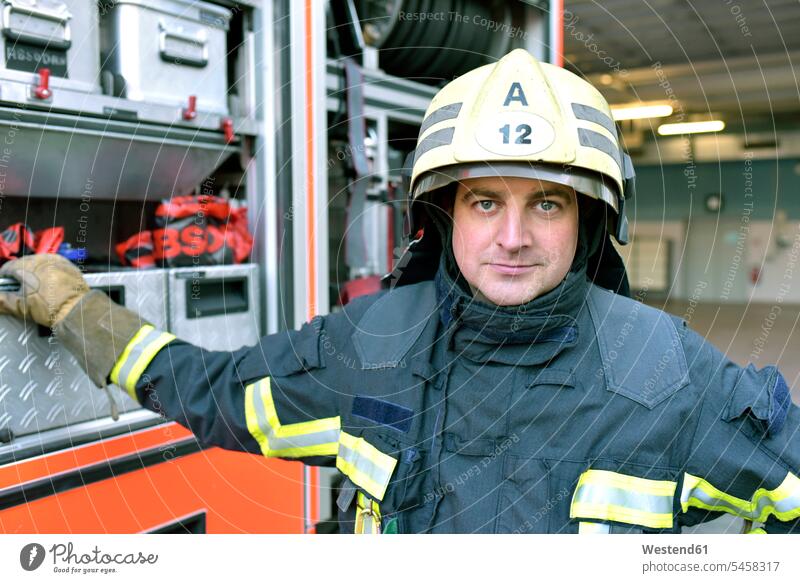 Portrait of confident firefighter in front of fire engine fireman confidence portrait portraits rescue vehicle Emergency Services Vehicle expertise