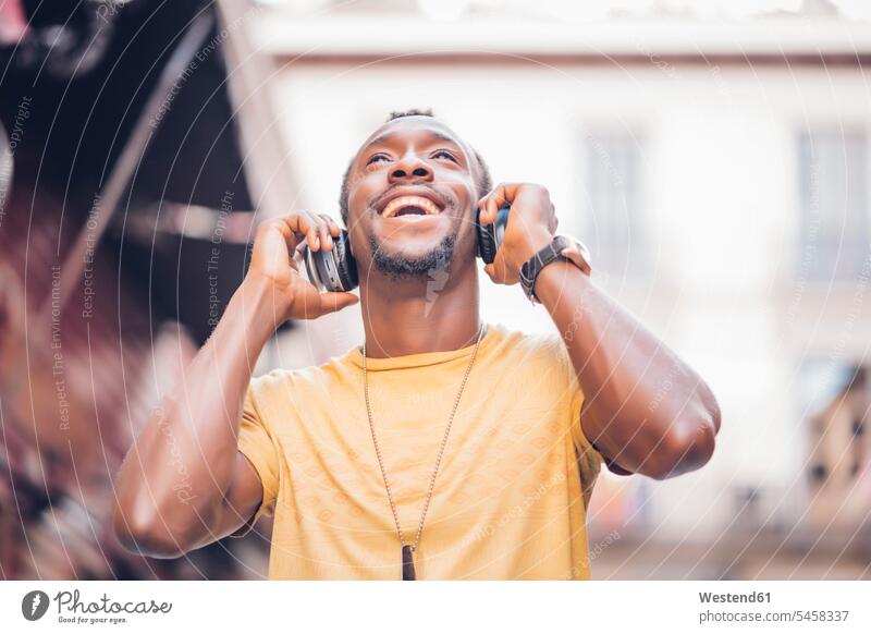 Portrait of happy man listening music with headphones looking up T- Shirt t-shirts tee-shirt jewelry necklaces headset relax relaxing hear relaxation delight