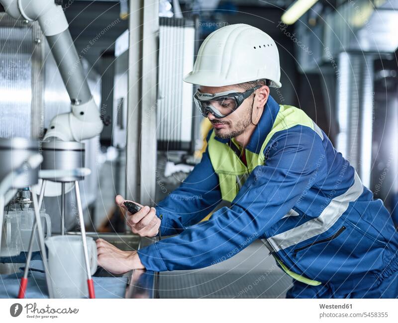 Rumania, woodworking, worker with protective workwear using stop watch stopping Monitoring Control controlling scrutiny scrutinising scrutinise scrutinizing