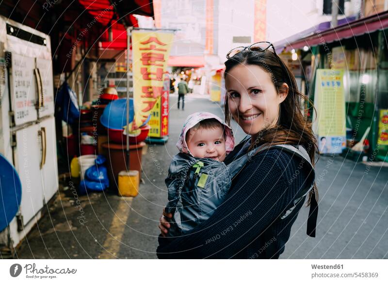 South Korea, mother and baby girl in a baby carrier visiting Busan portrait portraits smiling smile mommy mothers ma mummy mama infants nurselings babies