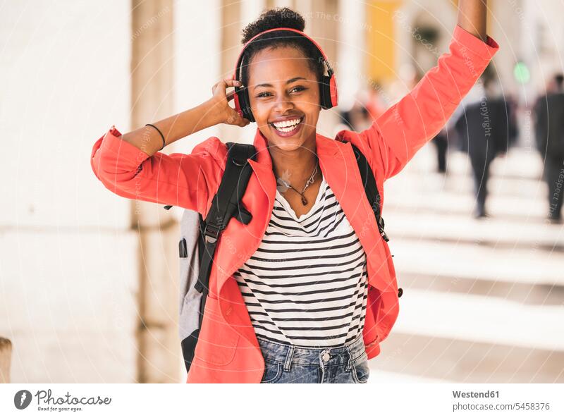 Portrait of happy young woman with headphones listening to music in the city, Lisbon, Portugal headset relax relaxing hear Ardor Ardour enthusiasm enthusiastic