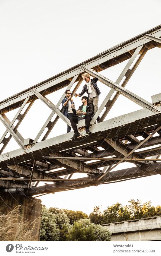 Three men drinking beer on an old railway bridge human human being human beings humans person persons caucasian appearance caucasian ethnicity european Group
