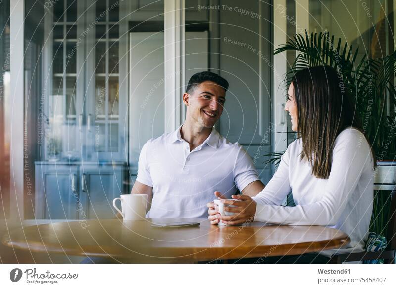 Couple drinking coffee while sitting at home boyfriend Boyfriends girlfriend Girlfriends girl friend girl friends color image colour image indoors indoor shot