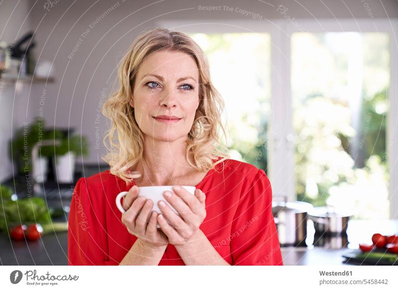 Portrait of woman drinking coffee in kitchen Coffee portrait portraits females women domestic kitchen kitchens Drink beverages Drinks Beverage food and drink