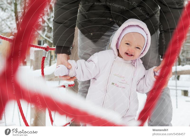 Portrait of smiling baby girl with father on playgroud in winter pa fathers daddy dads papa portrait portraits smile hibernal infants nurselings babies