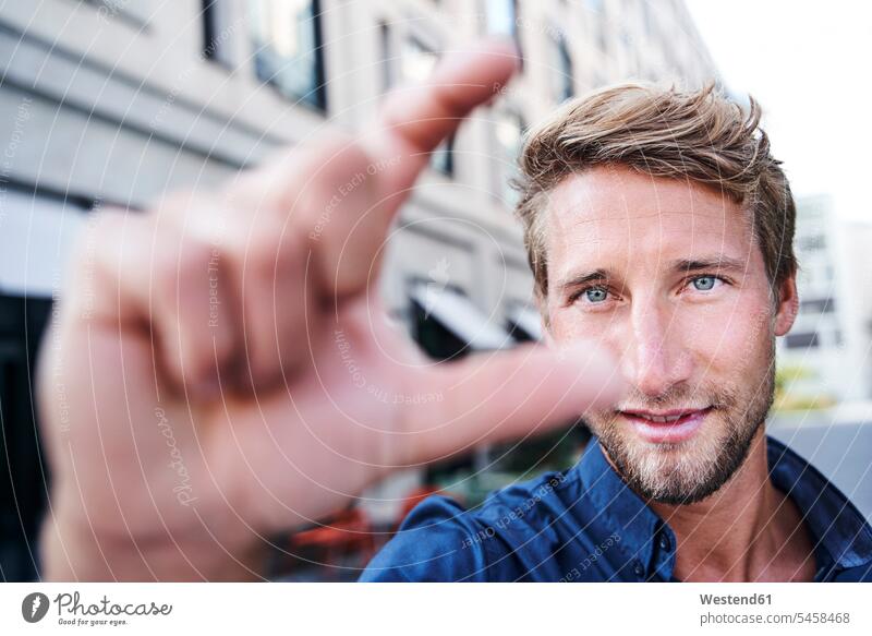 Portrait of young man gesticulating blue eye blue-eyed shirts smile Contented Emotion pleased colour colours shapes gesturing location shot location shots