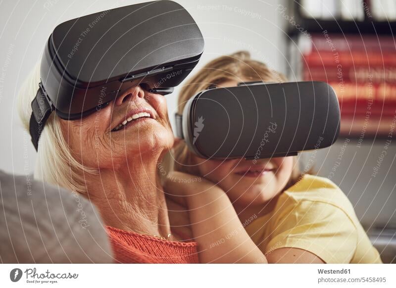 Grandmother using VR glasses with her grandson at home indoor indoor shot indoor shots interior interior view Interiors generation human human being