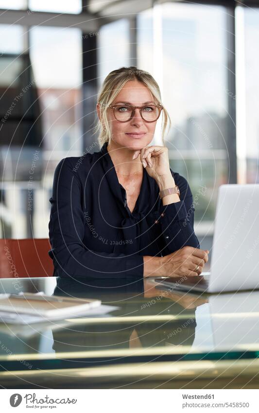 Businesswoman working in office, using laptop businesswoman businesswomen business woman business women sitting Seated business people businesspeople