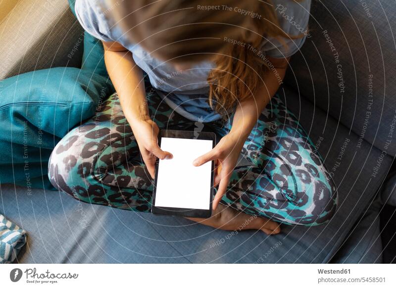 Top view of young woman sitting on couch at home using tablet human human being human beings humans person persons caucasian appearance caucasian ethnicity