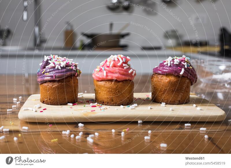 Homemade muffins in a row Rows Arrangement Positioning Positionings Arrangements studio shot studio shots studio photograph studio photographs sprinkled