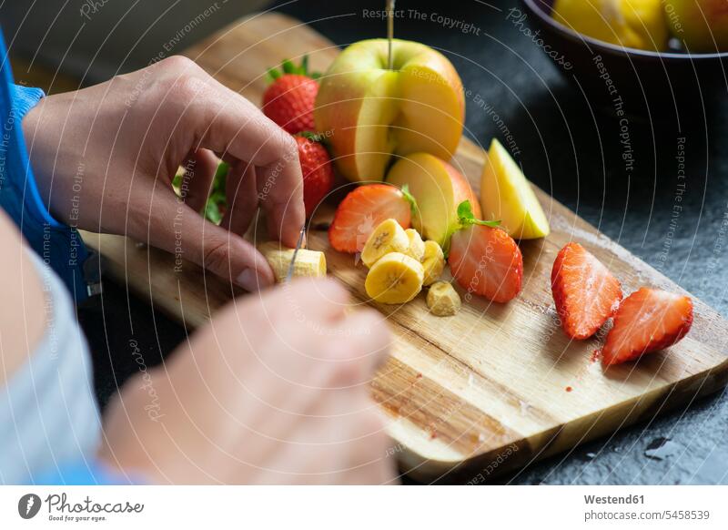 Woman chopping fruits in her kitchen, close up telecommunication phones telephone telephones cell phone cell phones Cellphone mobile mobile phones mobiles