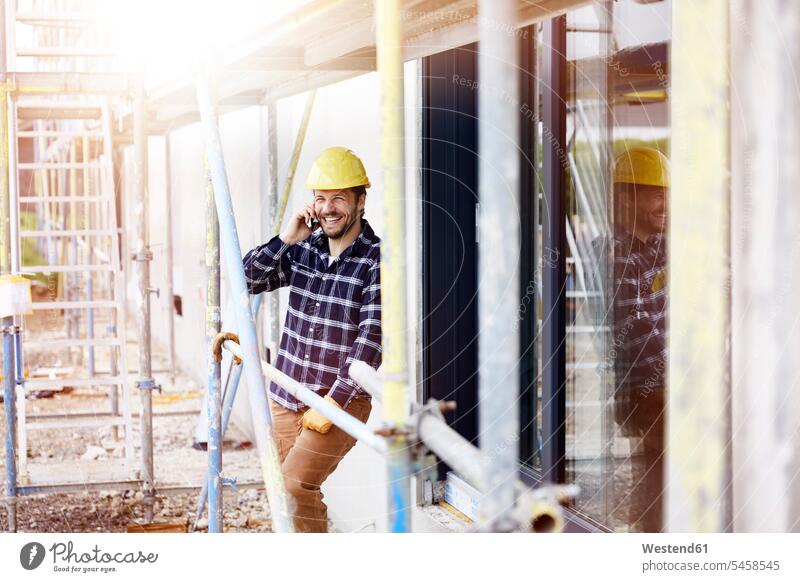 Happy worker on the phone a construction site Occupation Work job jobs profession professional occupation blue collar blue collar worker blue-collar worker