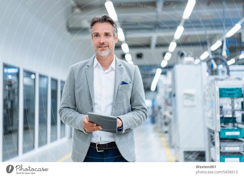 Businessman with tablet in a modern factory human human being human beings humans person persons caucasian appearance caucasian ethnicity european 1