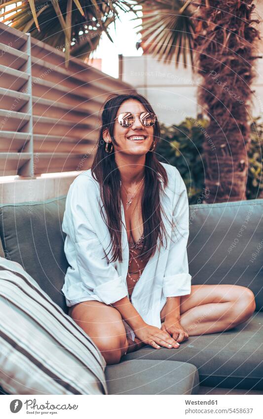Young woman in shirt and sunglasses sitting on a sofa outside home human human being human beings humans person persons caucasian appearance caucasian ethnicity