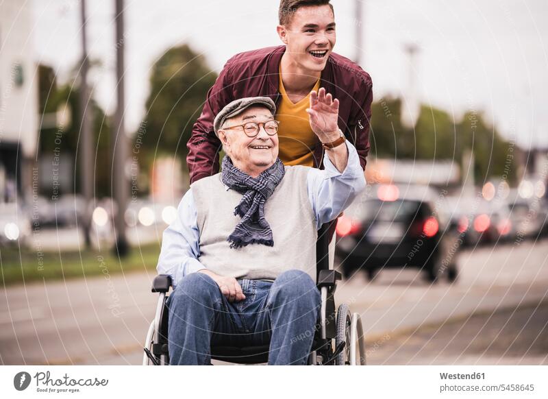 Portrait of laughing young man pushing happy senior man in wheelchair human human being human beings humans person persons caucasian appearance