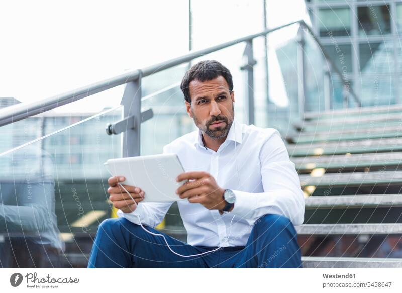 Businessman using tablet, earphone use Business man Businessmen Business men portrait portraits mobile working wireless Wireless Connection Wireless Technology